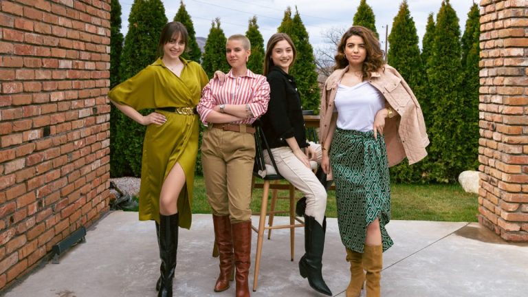Four women showcasing unique outfits and boots, posing confidently outdoors.