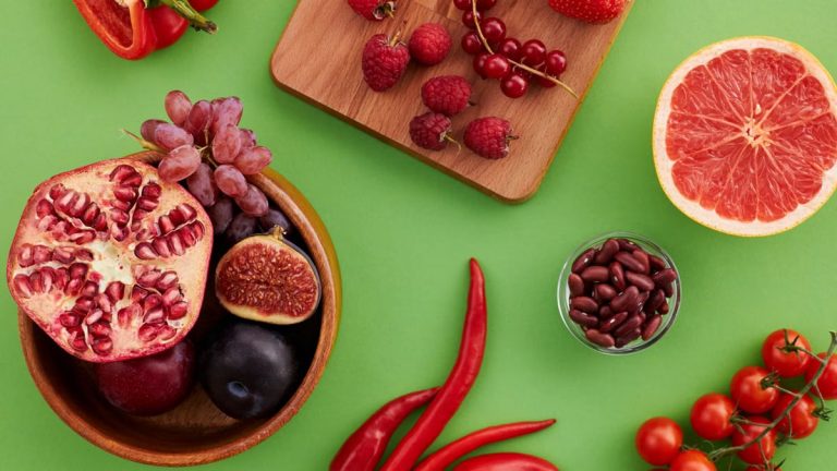 A vibrant display of fresh fruits and vegetables on a green surface.